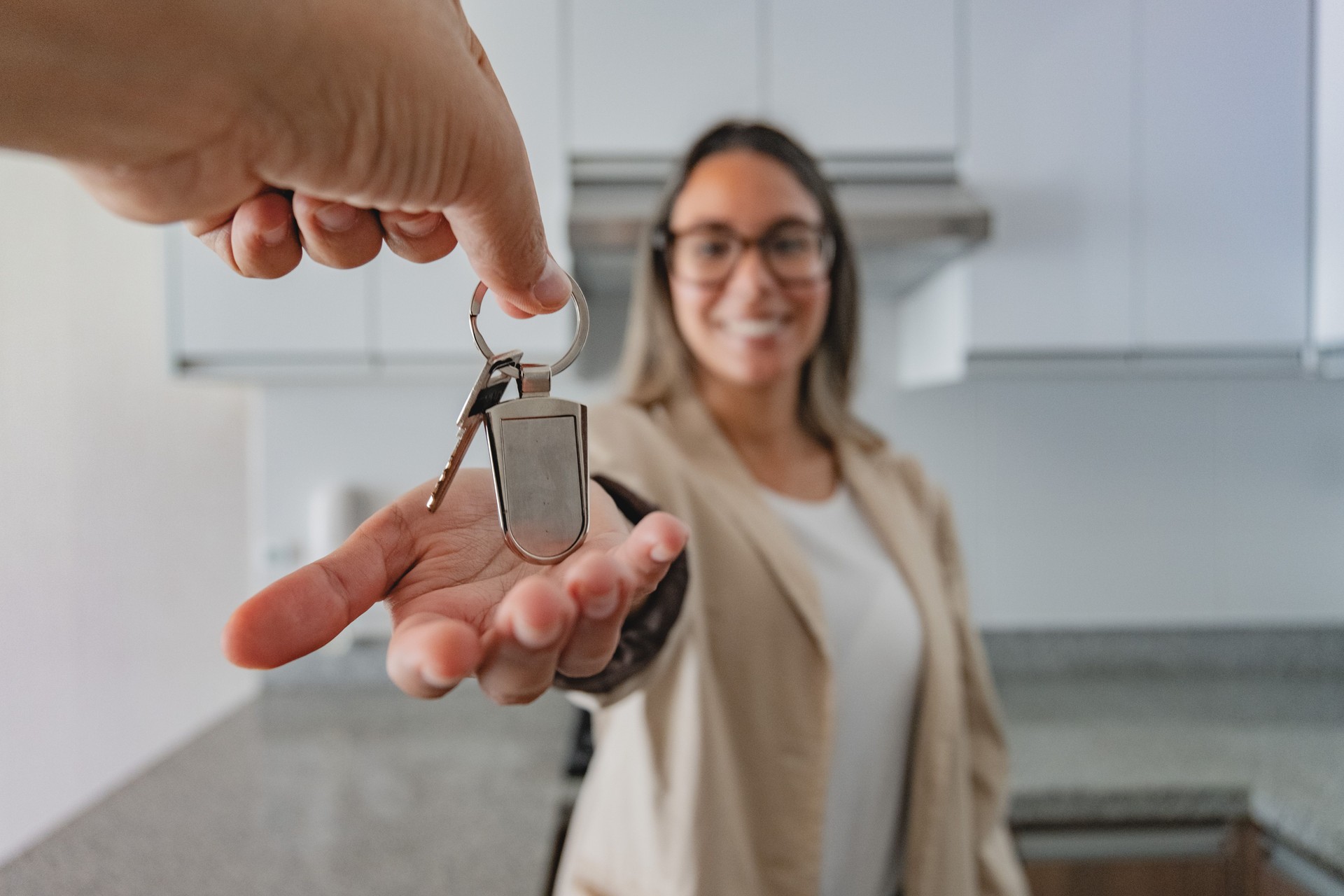 A woman is holding a key in her hand and smiling. New home concept.